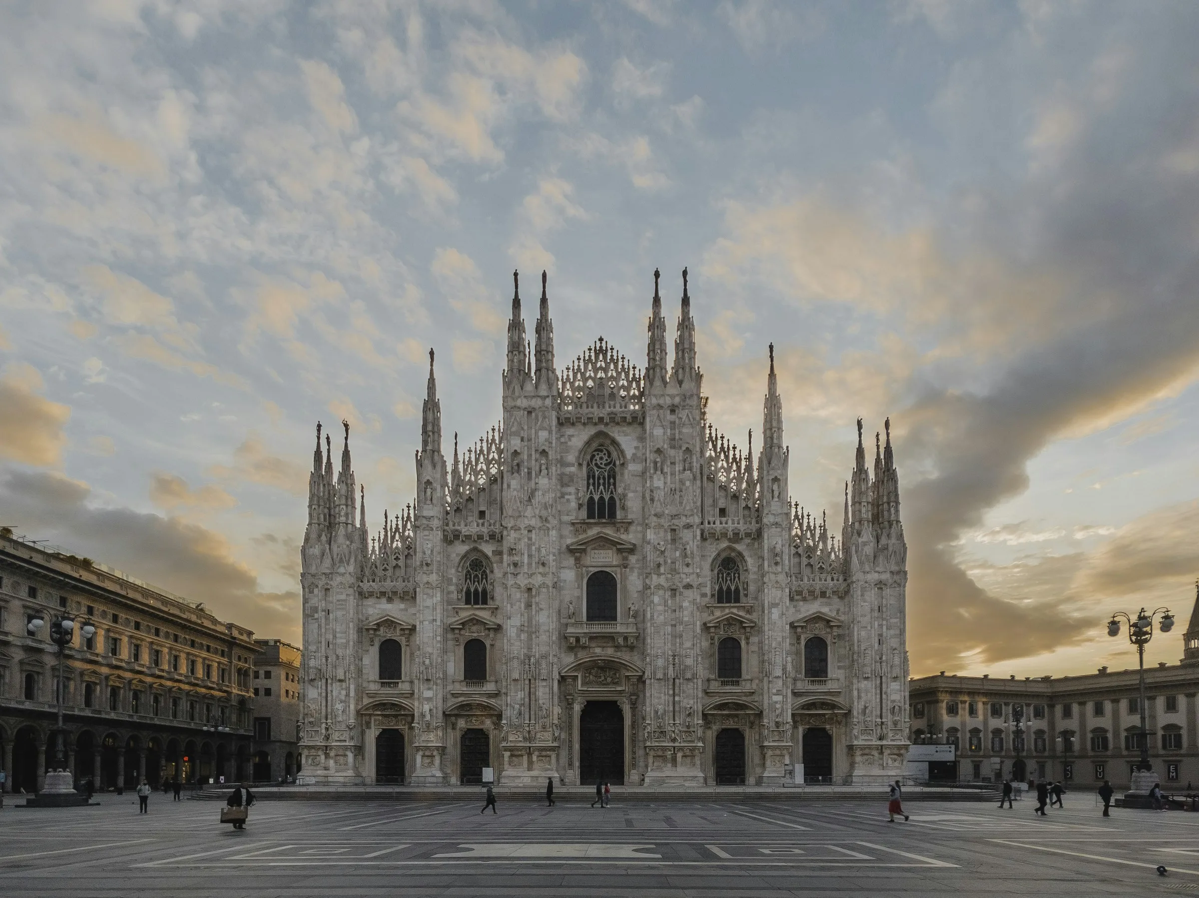 Milan Duomo cathedral facade at dusk with empty piazza